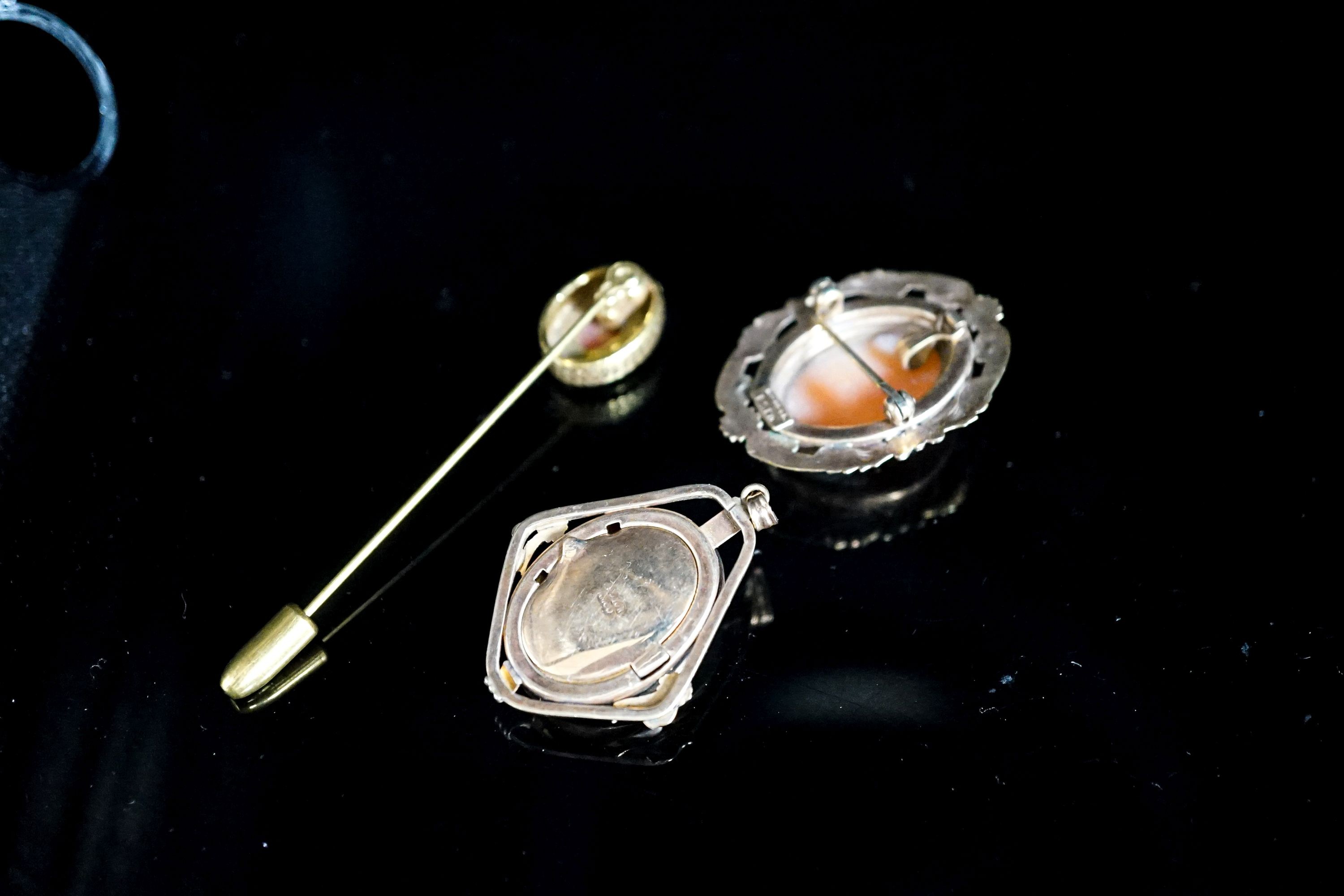 Two mounted cameo shell pendants, one with brooch attachment and a gilt metal cameo pin.